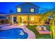 Backyard oasis features a sparkling pool, covered patio with seating, and lush artificial turf for low-maintenance enjoyment at 3270 W White Canyon Rd, San Tan Valley, AZ 85144