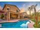 Backyard oasis with a private pool, covered patio, lush greenery, and palm trees, perfect for outdoor living and relaxation at 3270 W White Canyon Rd, San Tan Valley, AZ 85144