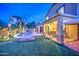 Backyard with a pool, covered patio, and low-maintenance artificial turf, perfect for outdoor living at 3270 W White Canyon Rd, San Tan Valley, AZ 85144