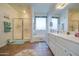 Bright bathroom with tile floors, a large mirror, and a bathtub under the window at 3270 W White Canyon Rd, San Tan Valley, AZ 85144