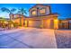 Attractive two-story home with a three-car garage and well-maintained landscaping, illuminated at twilight at 3270 W White Canyon Rd, San Tan Valley, AZ 85144
