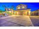 Charming home featuring a wide driveway and a three-car garage, illuminated by landscape lighting at twilight at 3270 W White Canyon Rd, San Tan Valley, AZ 85144