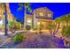 Inviting two-story home with a well-manicured yard, palm trees, and beautiful landscape lighting at 3270 W White Canyon Rd, San Tan Valley, AZ 85144