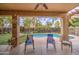 Relaxing covered patio overlooking a sparkling pool and lush backyard landscaping at 3270 W White Canyon Rd, San Tan Valley, AZ 85144