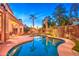 Beautiful backyard pool area with covered patio, outdoor lighting, privacy landscaping, and clear blue water at 3270 W White Canyon Rd, San Tan Valley, AZ 85144
