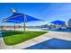 Stunning community pool area with shaded seating, artificial turf, and a pristine pool, offering residents a luxurious outdoor experience at 3270 W White Canyon Rd, San Tan Valley, AZ 85144