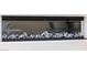 Modern fireplace with glass stones and blue flames against a textured white wall at 32771 N 70Th St, Scottsdale, AZ 85266