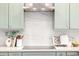 Elegant kitchen with a white backsplash, stainless steel appliances, and green cabinets at 32771 N 70Th St, Scottsdale, AZ 85266