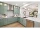 Stylish kitchen featuring custom green cabinetry, stainless steel appliances, and light wood flooring at 32771 N 70Th St, Scottsdale, AZ 85266