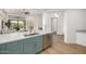 Open kitchen with stainless dishwasher, green cabinets, quartz counters, and view of living area at 32771 N 70Th St, Scottsdale, AZ 85266