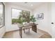 Bright office space with a large window offering views of lush greenery and a sleek wooden desk at 32771 N 70Th St, Scottsdale, AZ 85266