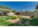 A fenced backyard with grass, gravel, and a covered patio area, needing landscape work at 339 E 9Th Dr, Mesa, AZ 85210