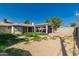 Wide shot of the backyard with grass, gravel, covered patio, and block wall, needing landscape at 339 E 9Th Dr, Mesa, AZ 85210