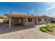 Tan home featuring a covered carport, security door, desert landscaping, and secure window bars at 339 E 9Th Dr, Mesa, AZ 85210