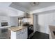 Open concept kitchen with stainless steel range, island, and adjacent living area at 339 E 9Th Dr, Mesa, AZ 85210