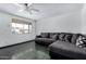 Open living space featuring durable dark tile, a window, ceiling fan, and a spacious sectional at 339 E 9Th Dr, Mesa, AZ 85210
