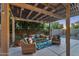 Relaxing patio with a shaded pergola, comfortable seating, and lush green plants at 3678 E Yeager Ct, Gilbert, AZ 85295