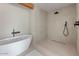 Minimalist bathroom featuring a soaking tub and modern shower with stone tile at 4035 E Mcdonald Dr, Phoenix, AZ 85018