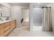Stylish bathroom featuring wood vanity, neutral tile, and a shower with white tiling at 4035 E Mcdonald Dr, Phoenix, AZ 85018