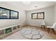 Bright bedroom with two windows, hardwood floors, a modern rug and two white chairs at 4035 E Mcdonald Dr, Phoenix, AZ 85018