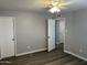 Spacious bedroom with a modern ceiling fan, light gray walls, and wood-look flooring at 4701 N 39Th Dr, Phoenix, AZ 85019