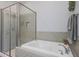 Elegant bathroom featuring a soaking tub with a shower and neutral tile surround at 4777 S Fulton Ranch Blvd # 1050, Chandler, AZ 85248