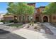 Lovely home featuring a stone accented facade, arched entry, and lush, green landscaping at 4777 S Fulton Ranch Blvd # 1050, Chandler, AZ 85248