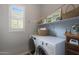 Organized laundry room featuring modern appliances, a shelf, and natural light from a shuttered window at 4777 S Fulton Ranch Blvd # 1050, Chandler, AZ 85248