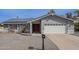 Charming single-story home with a red door, solar panels, and a well-maintained front yard at 514 E Barrus Pl, Casa Grande, AZ 85122