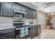 Well-equipped kitchen with stainless steel appliances, dark cabinetry, and a view to the brick fireplace at 514 E Barrus Pl, Casa Grande, AZ 85122