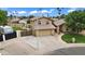 Two-story home with a stone and tan exterior, large driveway, RV gate, and well-manicured lawn at 609 W Mcnair St, Chandler, AZ 85225