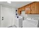 Functional laundry room with wooden cabinets, washer, and dryer ready for use at 609 W Mcnair St, Chandler, AZ 85225
