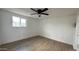 Well-lit bedroom featuring wood-look floors, a ceiling fan, and a window at 8125 E 5Th Ave, Mesa, AZ 85208