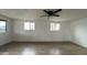 Bright living room with wood-look floors, white walls, a ceiling fan, and sunlit windows at 8125 E 5Th Ave, Mesa, AZ 85208