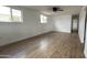 Spacious living room with wood-look floors, white walls, ceiling fan, and sunlit windows at 8125 E 5Th Ave, Mesa, AZ 85208