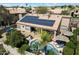 Aerial view showcases the home's backyard with a pool, patio, lush landscaping, and solar panels at 9059 E Butherus Dr, Scottsdale, AZ 85260