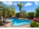 Beautiful pool area with lush landscaping, a rock waterfall, and a sun-drenched patio at 9059 E Butherus Dr, Scottsdale, AZ 85260