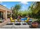 Backyard featuring a pool with a rock waterfall feature, seating area, and lush, mature landscaping at 9059 E Butherus Dr, Scottsdale, AZ 85260