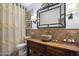 Charming bathroom with a vessel sink, wood vanity, decorative mirror, and shower showcasing elegant tile work at 9059 E Butherus Dr, Scottsdale, AZ 85260