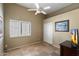 Cozy bedroom featuring neutral tones, a ceiling fan, closet and a window with shutters providing natural light at 9059 E Butherus Dr, Scottsdale, AZ 85260