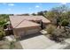 Exterior view of a charming home with a tile roof, three-car garage, and well-manicured landscaping at 9059 E Butherus Dr, Scottsdale, AZ 85260