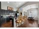 Open kitchen with dark cabinetry, granite countertops, bar seating, and adjacent dining area for easy entertaining at 9059 E Butherus Dr, Scottsdale, AZ 85260