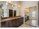 Spacious bathroom featuring double sinks, granite countertop, and mirrored closet at 9059 E Butherus Dr, Scottsdale, AZ 85260