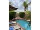 Inviting pool area with rock waterfall feature, lounge chairs, and lush tropical landscaping at 9059 E Butherus Dr, Scottsdale, AZ 85260