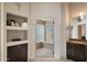 Bathroom with a glass block shower, built-in shelves, and custom vanity at 9059 E Butherus Dr, Scottsdale, AZ 85260