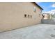 Backyard featuring a concrete patio, block wall, and multiple windows in the home's exterior at 9435 S 33Rd Dr, Laveen, AZ 85339