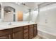 Bathroom featuring a double sink vanity, framed mirror, tile floors, and bathtub with shower at 9435 S 33Rd Dr, Laveen, AZ 85339