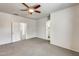 Spacious bedroom featuring a ceiling fan, carpet floors, and access to the bathroom at 9435 S 33Rd Dr, Laveen, AZ 85339