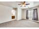 Bedroom with view into bathroom and a large window with gray drapes at 9435 S 33Rd Dr, Laveen, AZ 85339