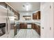 Charming kitchen with stainless steel appliances, wooden cabinetry, light countertop, and lots of natural light from the window at 9435 S 33Rd Dr, Laveen, AZ 85339